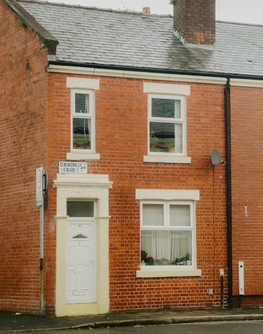 end-of-terrace Red brick end of terrace house with a white front door