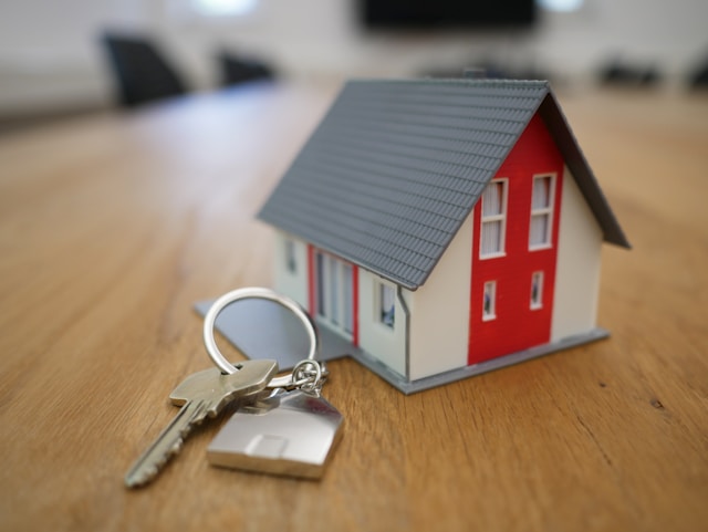tierra-mallorca-rgJ1J8SDEAY-unsplash Red and white minature house sat on a wooden table beside a key on a keyring