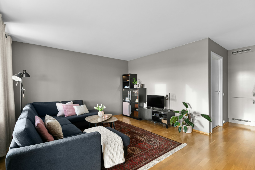home-renovation Lounge with grey corner sofa, wooden floors and grey walls